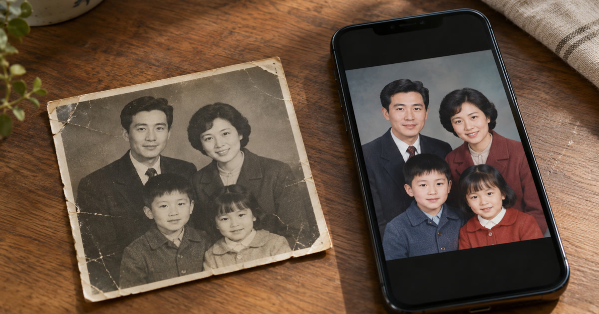 Photograph of an old, slightly worn black-and-white family photo , next to a phone showing a restored color version